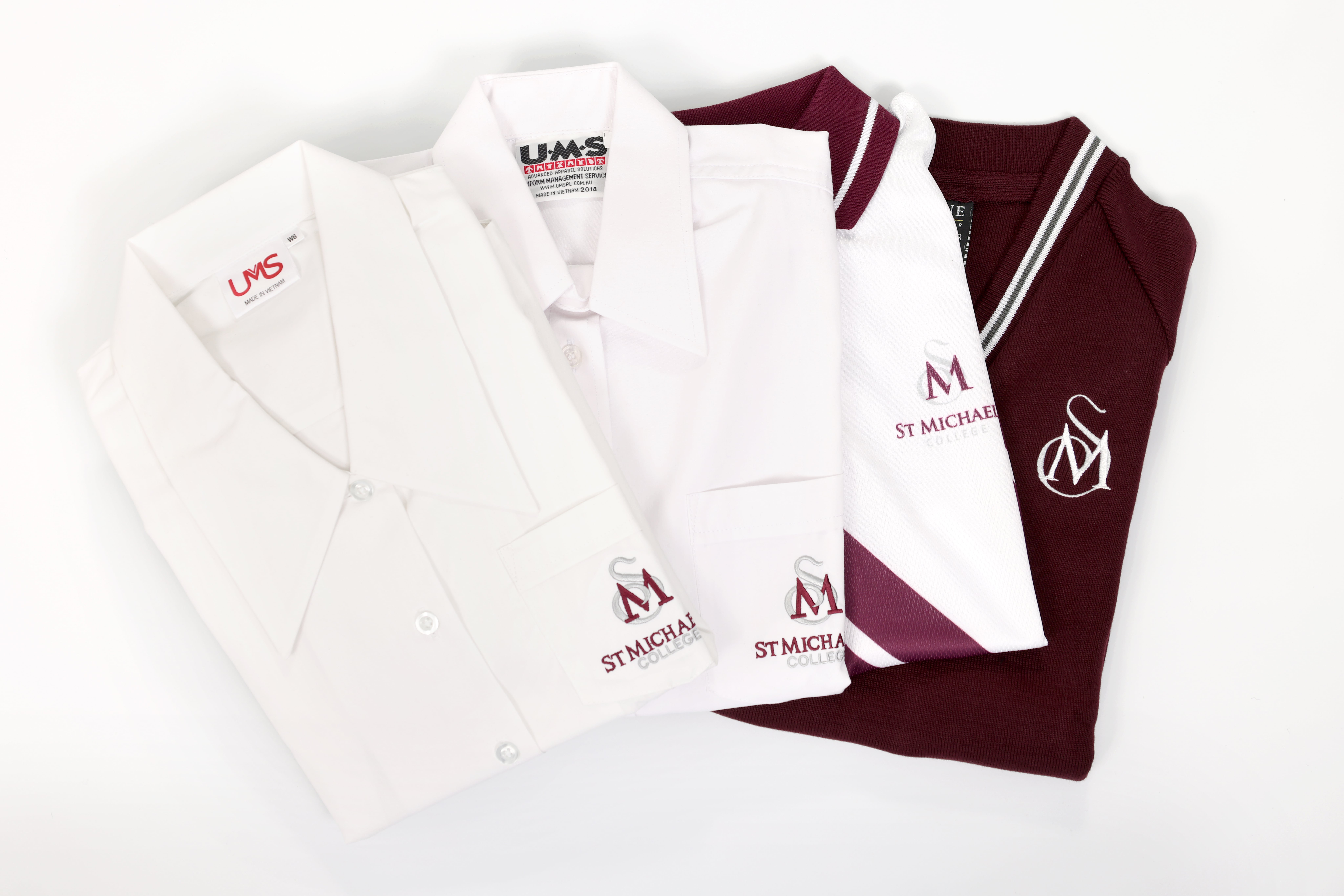 St Michael’s College uniform items including white shirt, polo shirt, tie and maroon jumper displayed neatly together